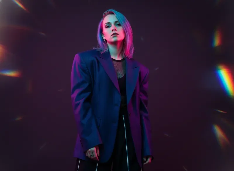 Emerging LGBTQ artist portrait with neon pink and cyan lighting