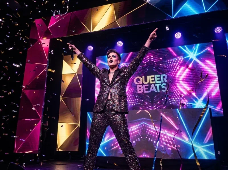Mainstream LGBTQ pop star performing on a grand stage